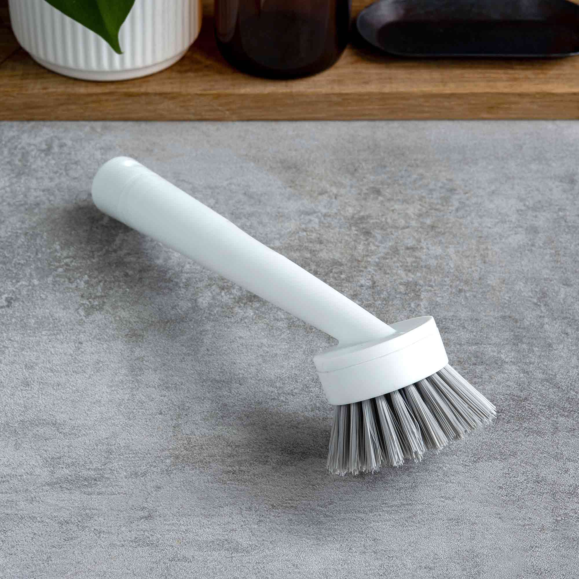 Kitchen brush with a white handle on a gray surface. Simply Clean Scrub Brush - White