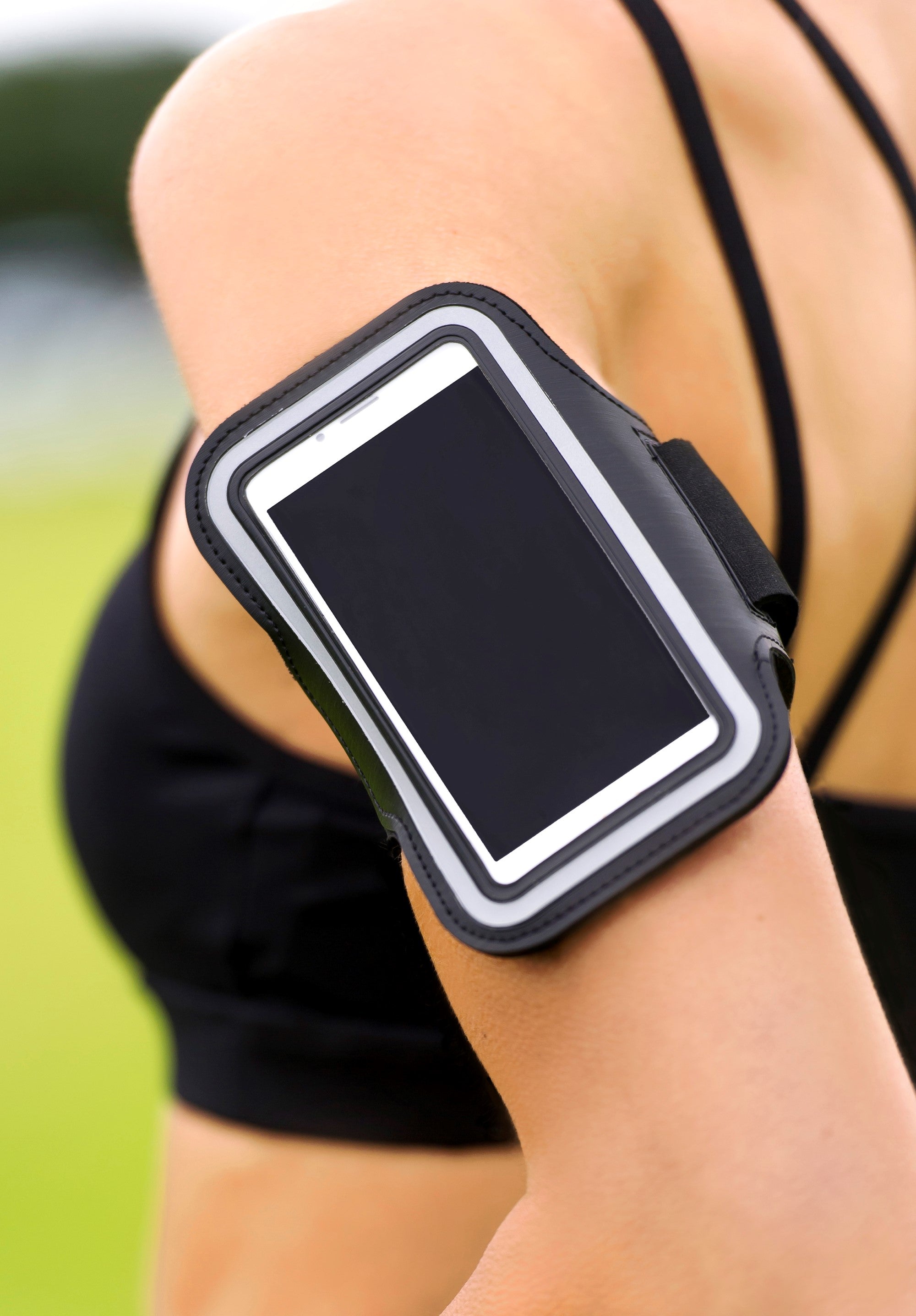 Black arm band with a reflective strip worn on an arm, likely for sports or exercise. Simply Clean Active Armband
