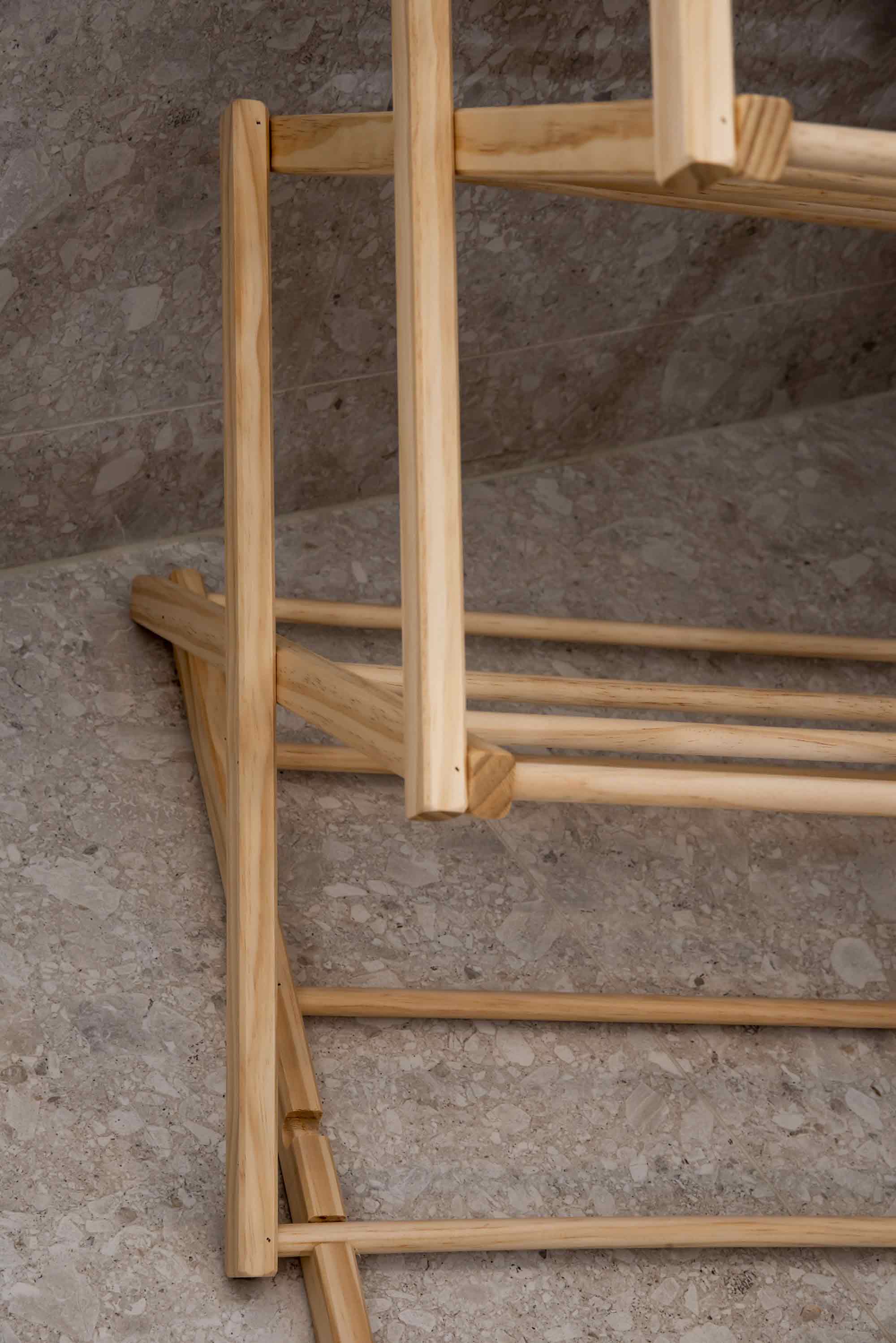 Wooden clothes airer on a stone floor. Victoria James Home Eco Deluxe Clothes Airer