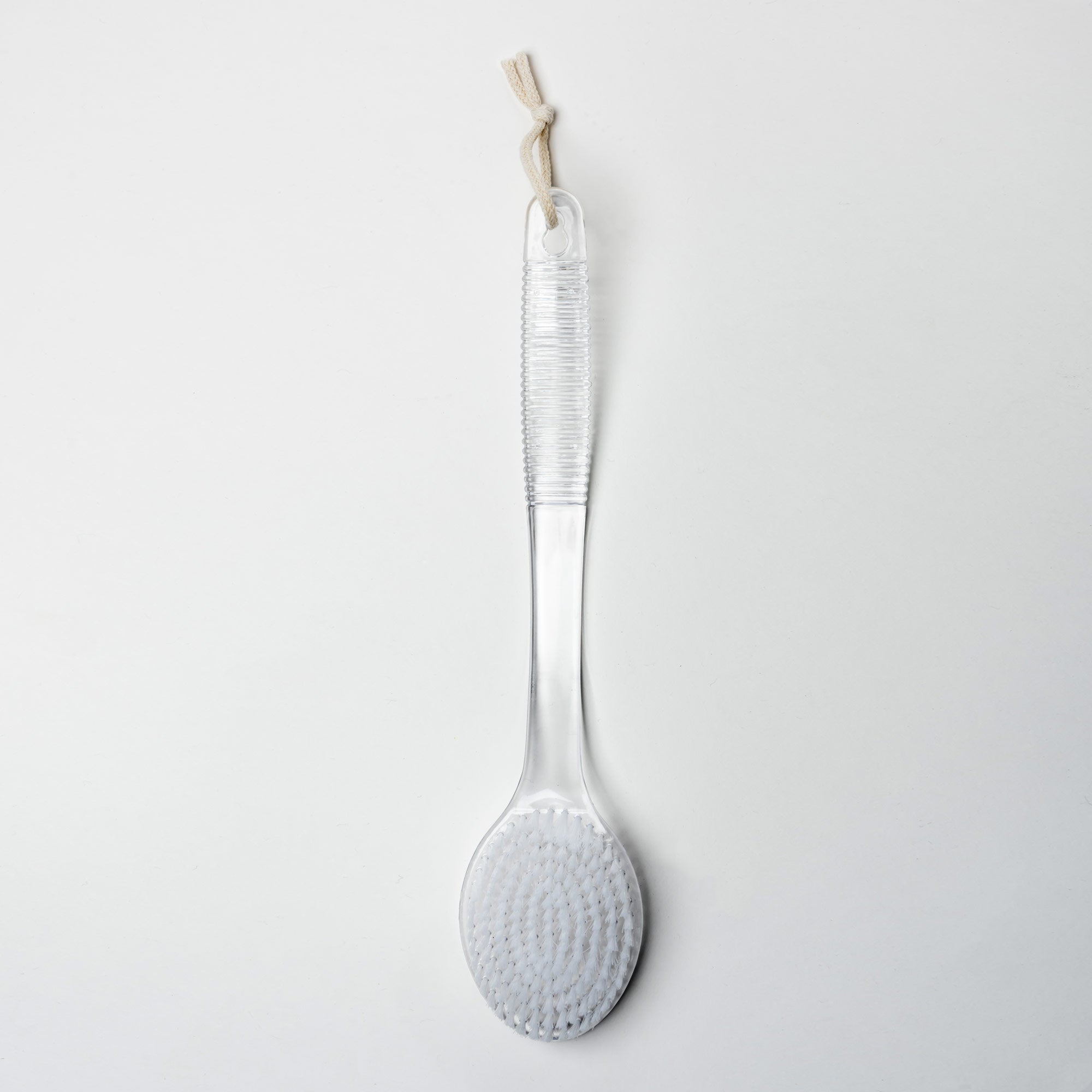 Clear bath brush with textured head on a white background., Victoria James Body Bath & Shower Brush